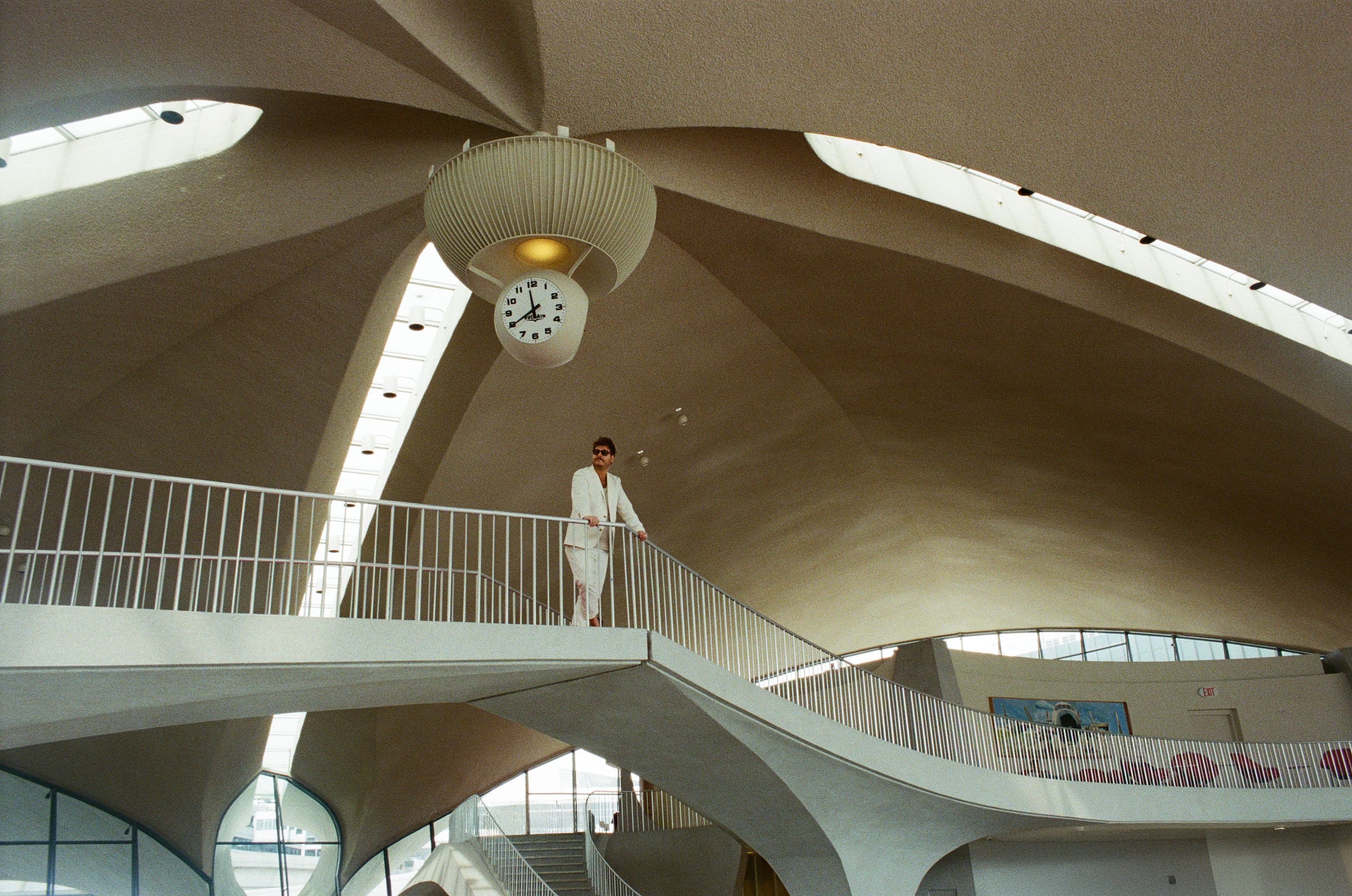 Riviera musician Michael Rabb standing in a cinematic mid-century architectural interior